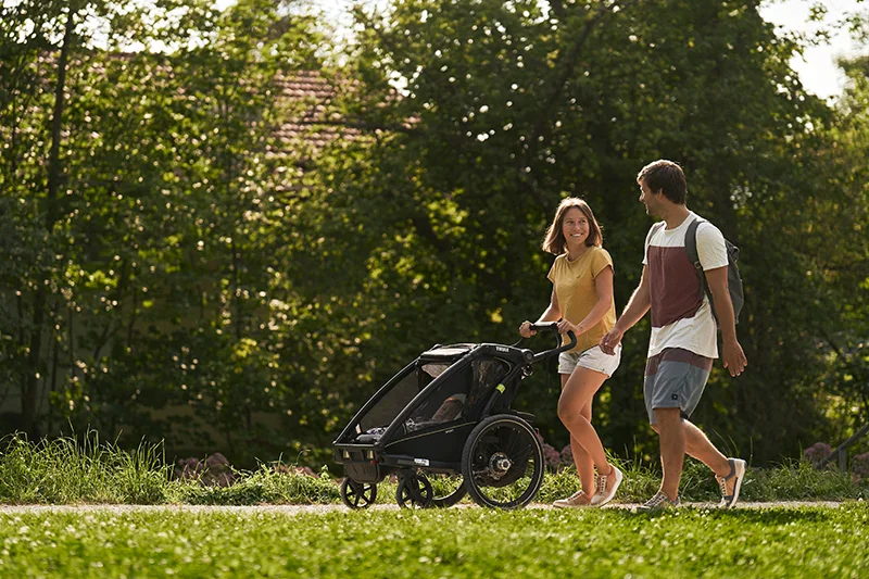 pärchen mit kinderwagen trägt barfußschuhe