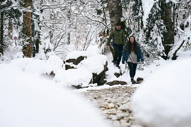 pärchen trägt im winter bei einer wanderung barfußschuhe