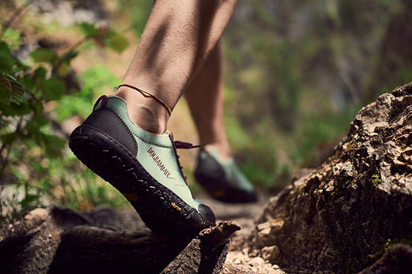 Barfuß Wanderschuhe in mint steht auf einem Stein