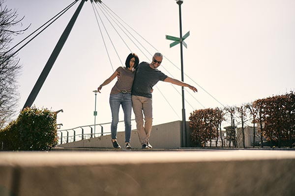 zwei menschen tragen sommer barfußschuhe und laufen auf einer mauer