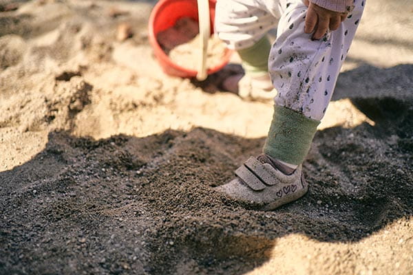 mädchen lernt mit lauflernschuhen gehen