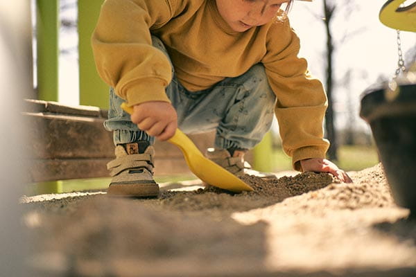 kinder barfußschuhe werden im sandkasten getragen