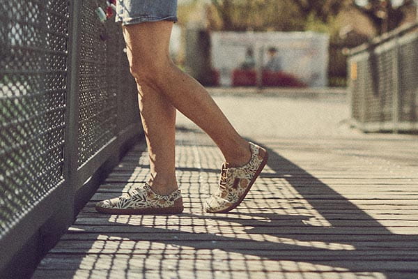 barfußschuh sneaker damen in blumenmuster wird von einer frau getragen width=